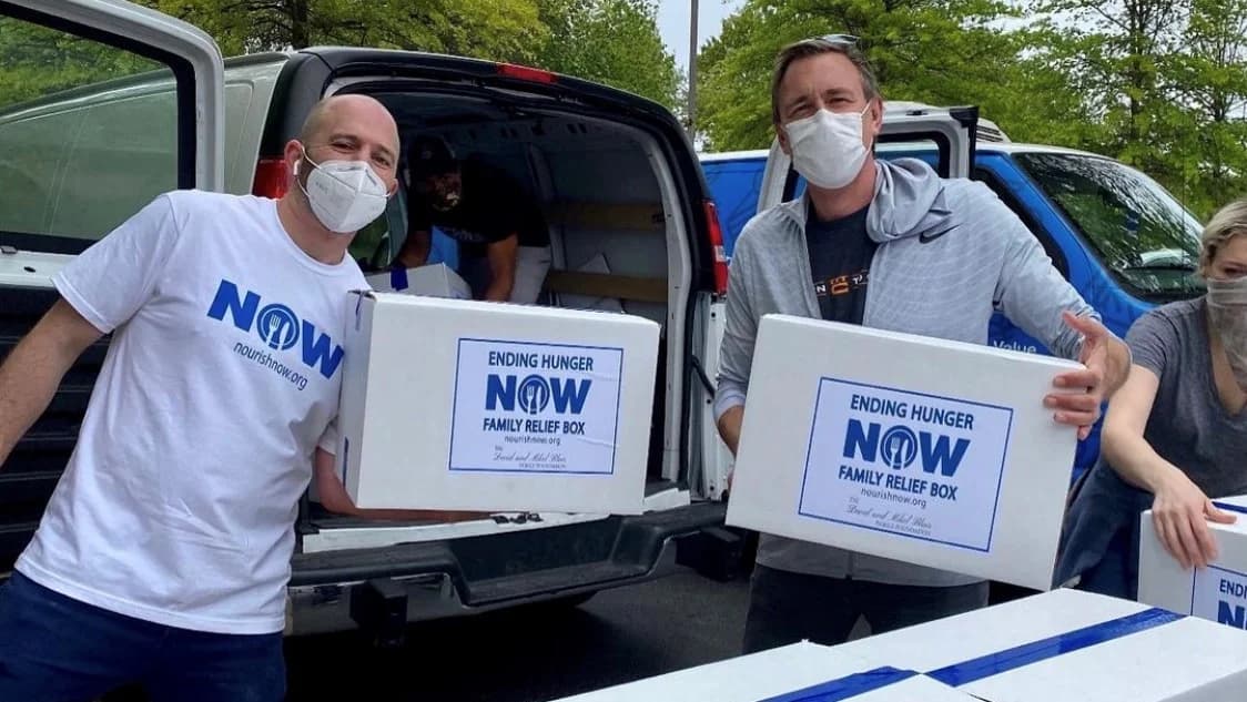 Nourish Now volunteers holding food boxes